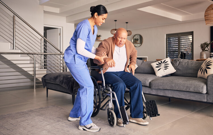 Nurse helping man in wheelchair, home and trust for medical service, physical therapy and support in retirement. Caregiver, woman and aid old patient with disability, rehabilitation and healthcare. When Coverage Changes: How To Provide Stable Home Rehab 