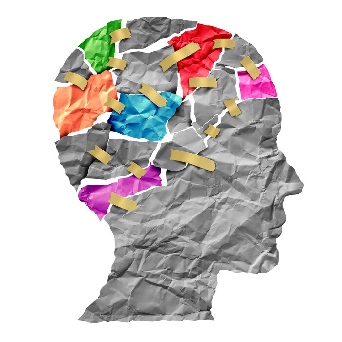 Brain Injury Basics -gray paper outline of a skull with rips and tears taped together